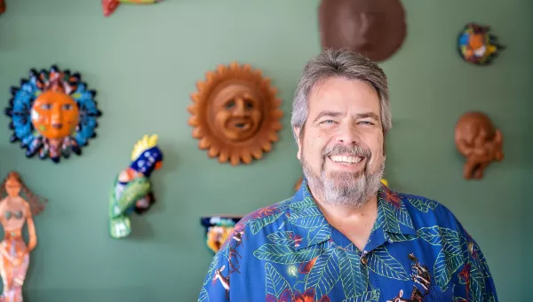 Man smiling in front of art work