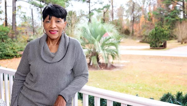 lady standing on front porch smiling at camera