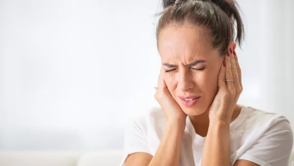 Woman holding her ears in pain