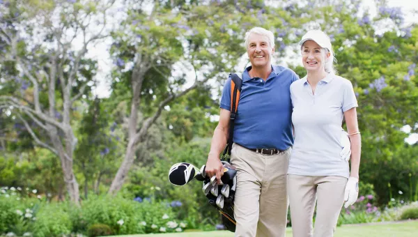 man and woman walking on golf course